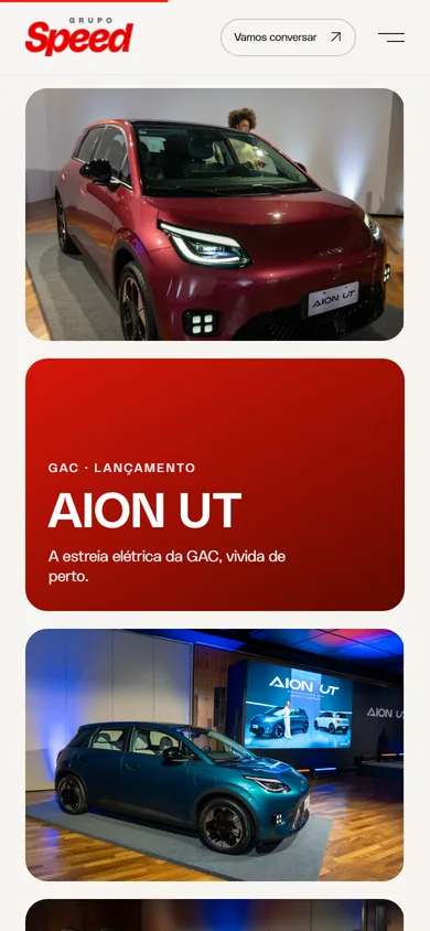 O mosaico no celular, empilhado: a foto do AION UT vinho, o bloco vermelho e o carro azul diante do telão